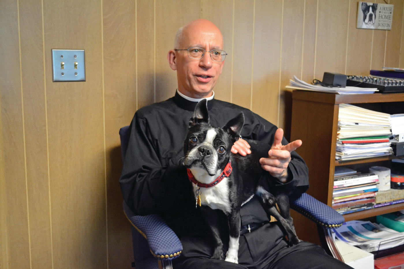 PASTORAL PET: Father Andrew Messina inside his office at St. Timothy Church with his trusty companion, Max the Boston terrier.